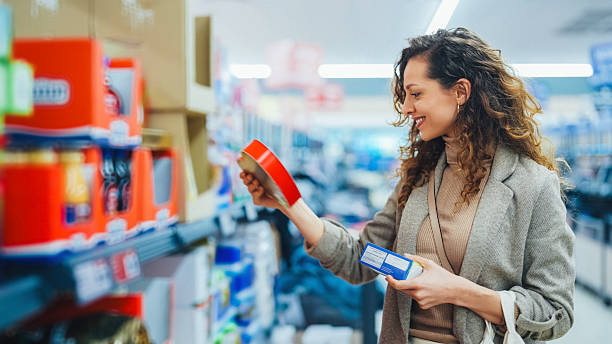 istock Woman comparing products while shopping at supermarket 2216309576
