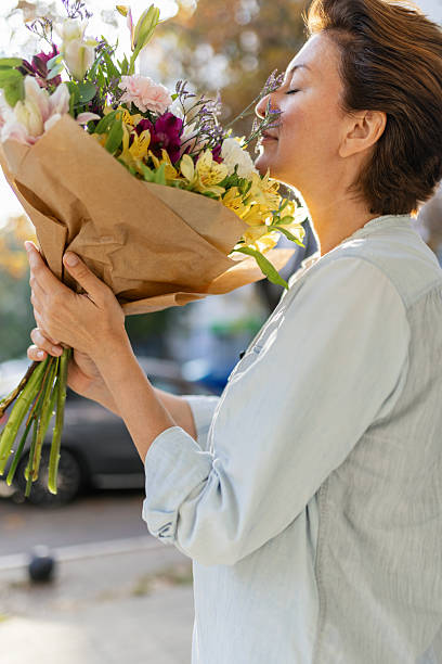 istock Beautiful woman smelling a bouquet 2216312278