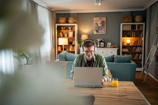 istock Young man working from home on his laptop and smiling 2216313779