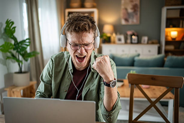 istock Excited young man celebrating success while working from home 2216313954
