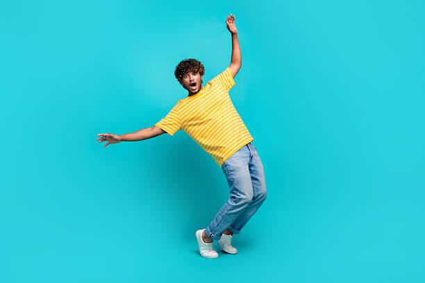 istock Full size photo of handsome young guy frightened avoid falling dressed stylish striped yellow outfit isolated on cyan color background 2216314227