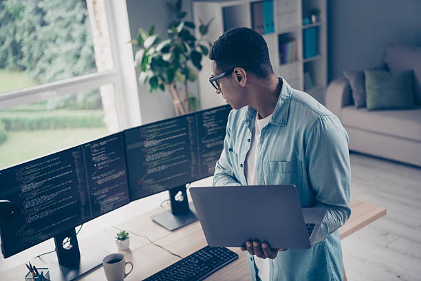istock Photo of young it specialist system administrator control server working correctly young guy holding macbook hacking computers in office 2216314233
