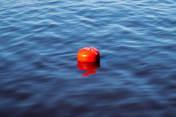 Red buoy floats on the blue undulating surface of the lake.