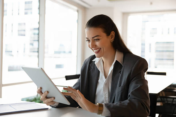 istock Happy businesswoman sitting at desk using tablet with positive expression 2216318137