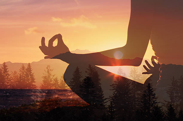 istock Young woman meditating in sunset forest setting. 2216320489
