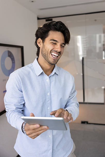 istock Businessman laughs on entertaining content he read on tablet 2216323341