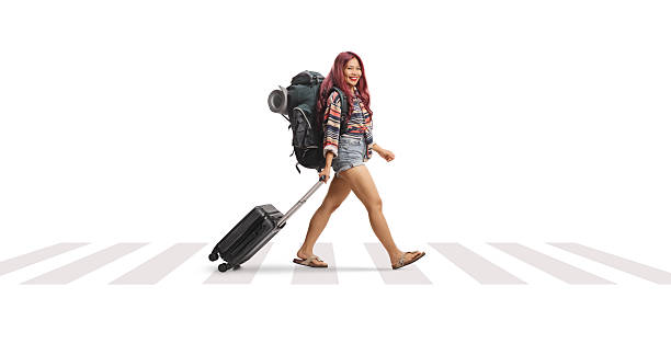 istock Asian female tourist pulling a suitcase at a zebra crossing 2216325125