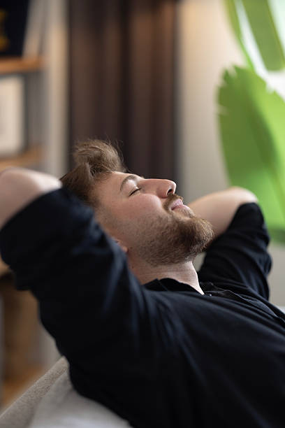 istock Happy dreamy young man relaxing at home 2216326930