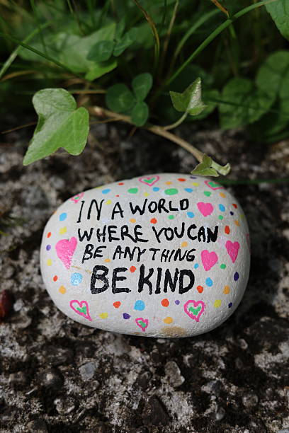 istock Old stone surface with vine plant and be kind kindness rock vertical photo 2216327067