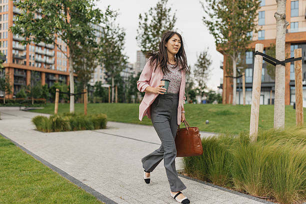 istock Businesswoman enjoying coffee while walking 2216327619