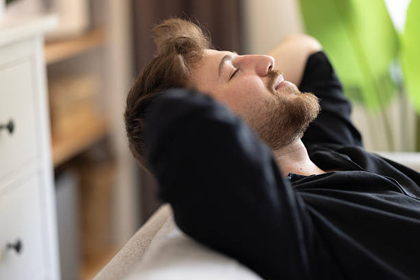 istock Happy dreamy young man relaxing at home 2216328996