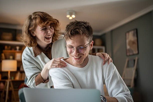 istock Young couple laughing and having fun while working from home 2216331009