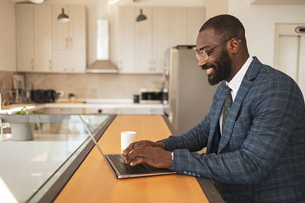 istock Professional man working on a laptop in a bright modern kitchen office 2216331104