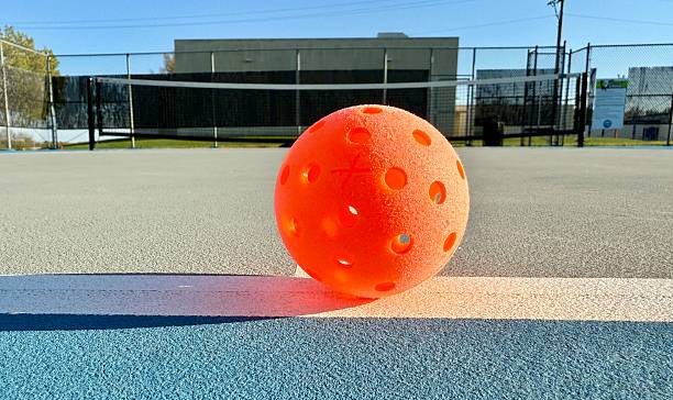 istock Orange Ball on Fresh Green Pickleball Cout 2216331499