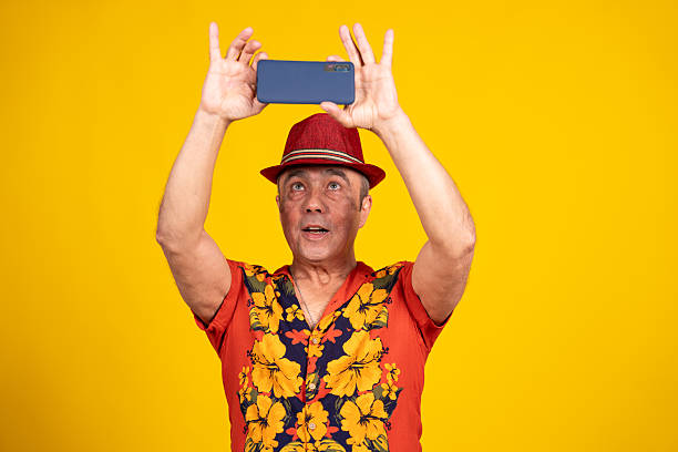 istock Tourist taking a picture with smartphone on yellow background 2216331897