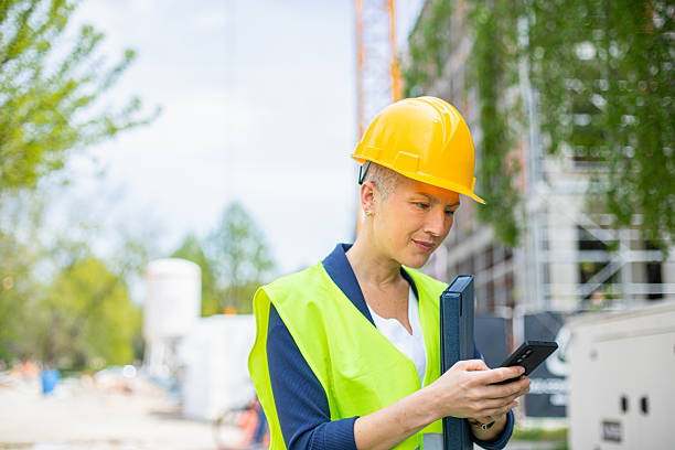istock Female supervisor in front of construction site using phone 2216331901