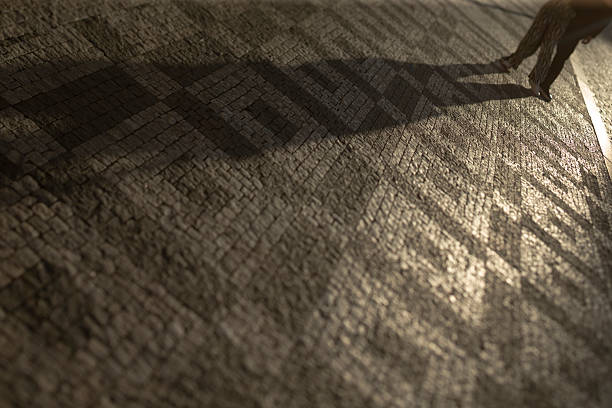 istock A captivating shadow play unfolds on the paved walkway as dusk falls 2216332155