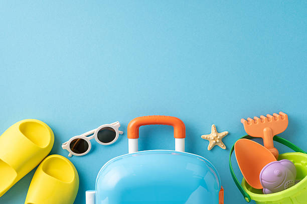 istock Bright summer vacation essentials including sunglasses, a suitcase, sandals, and colorful beach toys 2216334944
