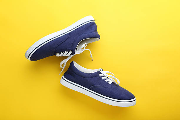 istock Blue sport shoes on yellow background 2216335622
