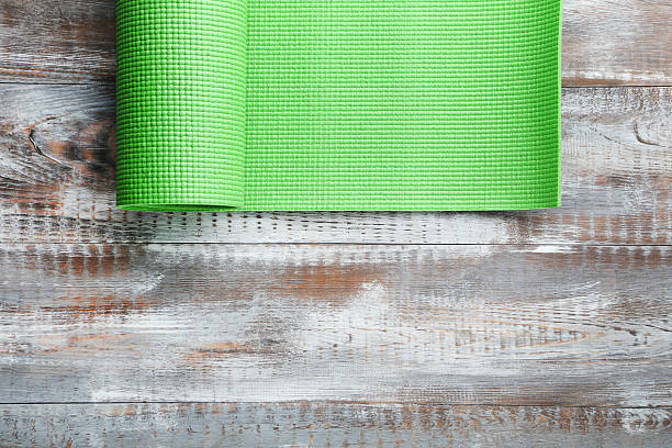 Fitness mat on grey wooden table