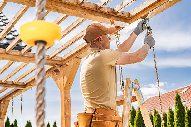 istock Construction Worker Installs Wooden Beams on Outdoor Structure in Bright Afternoon Light While Using Ladder and Tools 2216336220