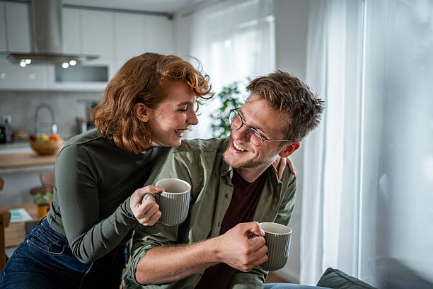 istock Young couple laughing and drinking coffee at home 2216339904