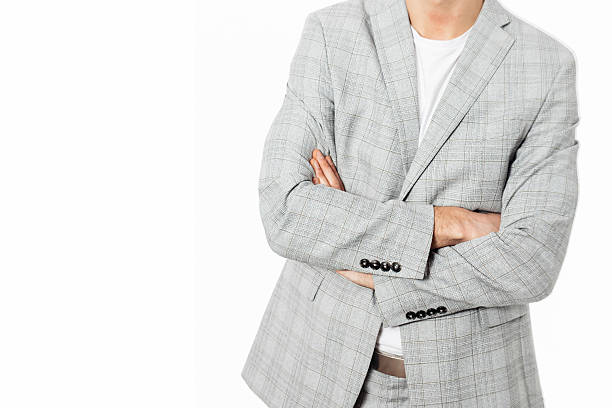 Stylish businessman in a gray suit posing on a plain white background. Ideal image for corporate, fashion, or recruitment-related themes.