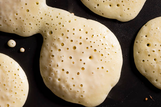 baking small pancakes with butter in a frying pan, hot metal pan while cooking pancakes with butter