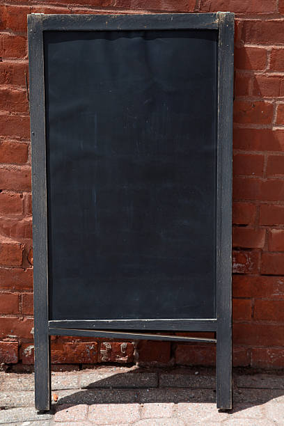 istock Blank Blackboard Vertical Poster with Copy Space on Brick Wall Background 2216344437