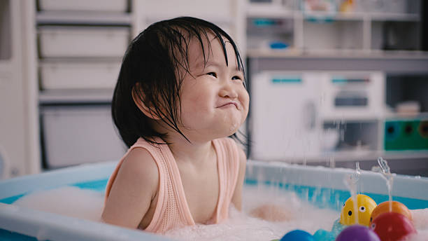 A little girl enjoying a good time in her bathroom at home while taking a bath.