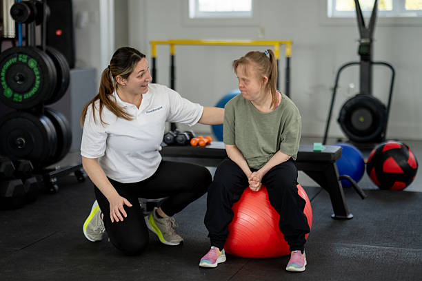 istock Fitness Instructor Assisting Individual on Stability Ball in Training Session 2216352377