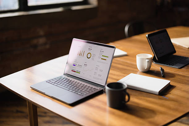 istock Laptop displaying business charts and graphs on a wooden table 2216352529
