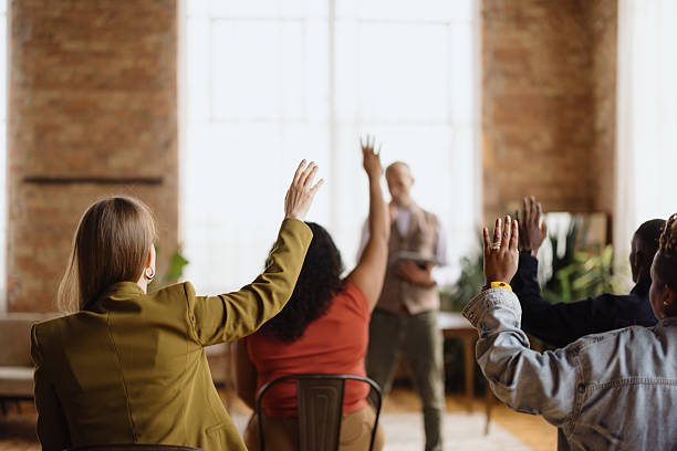 istock Audience raising hands to ask questions during a business conference 2216352784