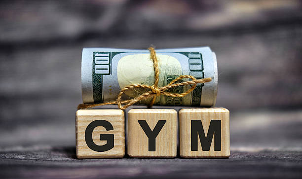 istock GYM - text on wooden cubes with dollars 100 bills 2216353207