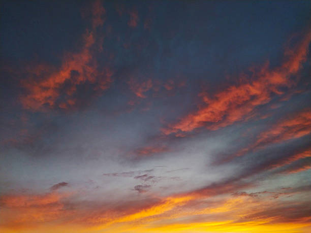 istock Dramatic sky ablaze with fiery orange clouds against a deep blue backdrop. Evokes emotion, transition, or the power of nature. Perfect for backgrounds or inspirational themes. 2216353254