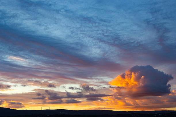 Dramatic sunset sky with colorful clouds over a dark horizon. Evokes peace and wonder. Great for travel, nature, or inspirational content.