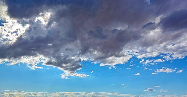 Dramatic sky scene Cumulus clouds contrast with the azure sky. Evokes hope, change, or foreboding. Perfect for backgrounds, weather reports, or metaphorical usage.