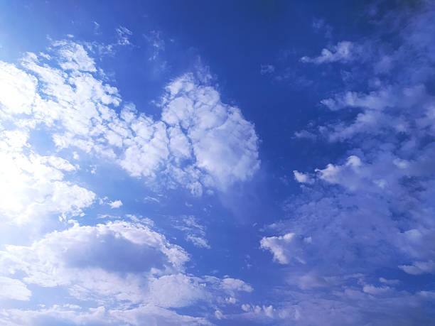 Vibrant blue sky filled with fluffy white clouds. Ideal for backgrounds, atmosphere, or representing hope and freedom. Serene, calming, and visually appealing.