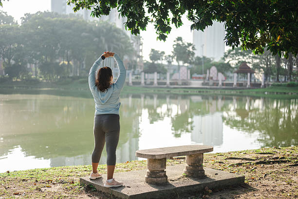Portrait of an Asian Indian athlete stretching by the lakeshore, getting ready for their morning exercise.