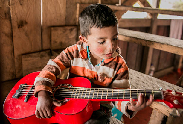 Cheerful boy playing ukelele
