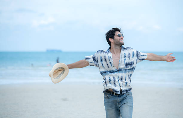 istock Young man on vacation on a white sandy beach, clear sky and sea 2216367459
