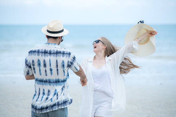 istock Young couple on vacation on a white sandy beach, clear sky and sea 2216367461