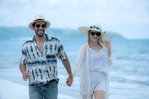 istock Young couple on vacation on a white sandy beach, clear sky and sea 2216367490