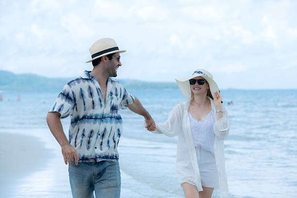 istock Young couple on vacation on a white sandy beach, clear sky and sea 2216367492
