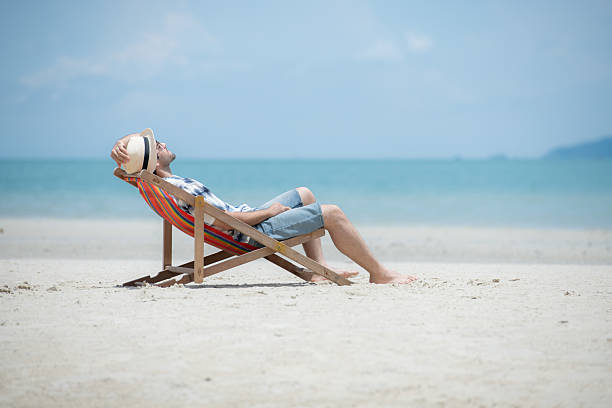 istock Young man on vacation on a white sandy beach, clear sky and sea 2216368182