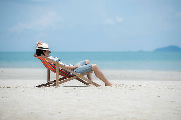 istock Young man on vacation on a white sandy beach, clear sky and sea 2216368188