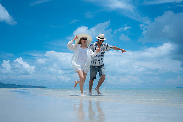 istock Young couple on vacation on a white sandy beach, clear sky and sea 2216368214