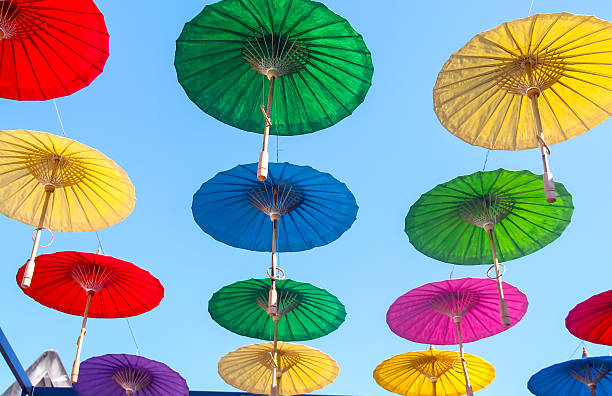 istock Open umbrella hanging on bright blue sky outdoor summer background 2216369927