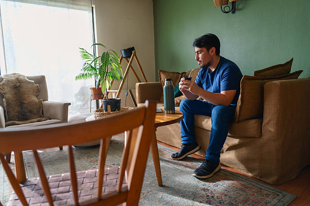 istock Chilean man drinking mate in cozy living room 2216373599