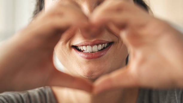 istock Woman smiling and making heart shape with her hands 2216381694